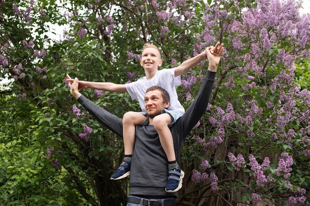 Papa a ramassé et mis un enfant mignon sur ses épaules Son fils vole comme un avion