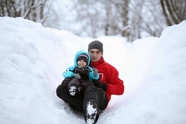 Papa roule avec un toboggan avec un jeune fils