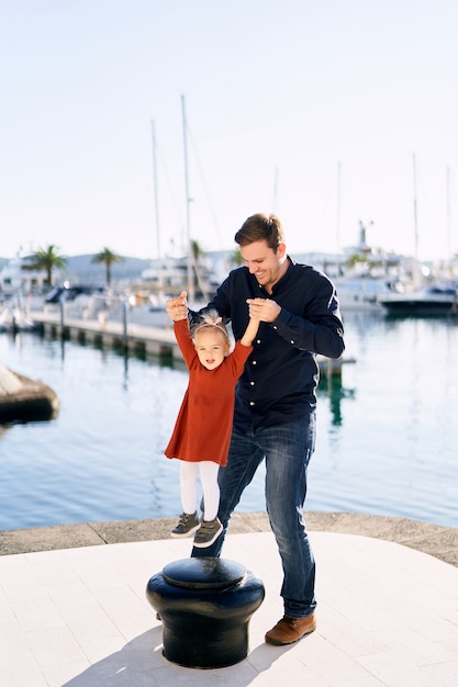 Papa s'amuse avec sa fille dans une marina au Monténégro.