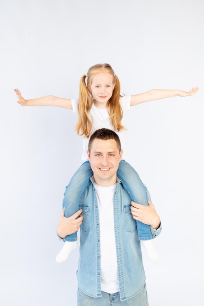 Papa et sa fille sur leurs épaules souriant et s'amusant sur un fond blanc isolé espace vide pour texte famille heureuse ou paternité