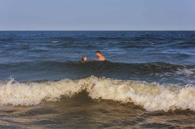 Papa et sa fille nageant dans la famille de l'océan sur la plage en vacances