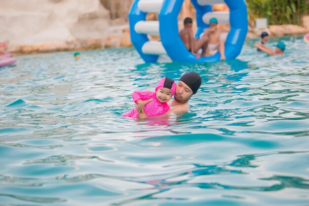 Papa et sa fille nageant à la piscineThaïlandais