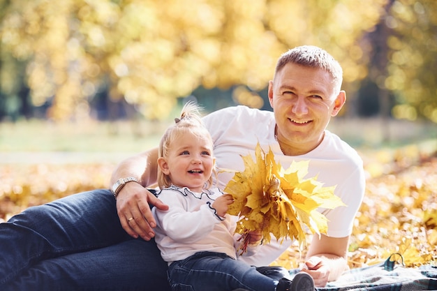 Papa avec sa petite fille se repose dans un magnifique parc d'automne aux beaux jours.