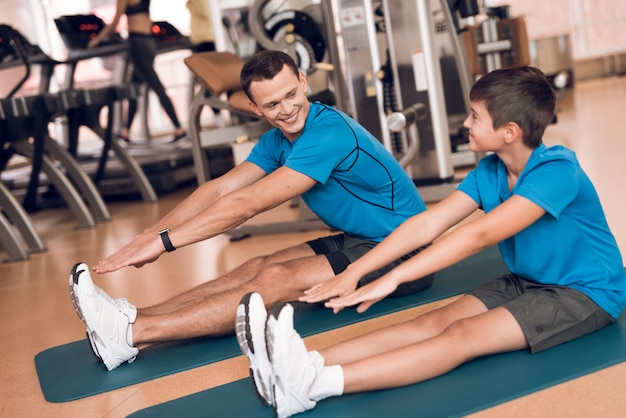 Papa Et Son Fils Font Des étirements Dans Le Gymnase.