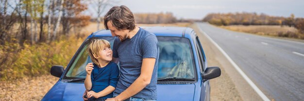 Papa et son fils se reposent sur le bord de la route lors d'un voyage en voiture. Voyage en voiture avec concept d'enfants.