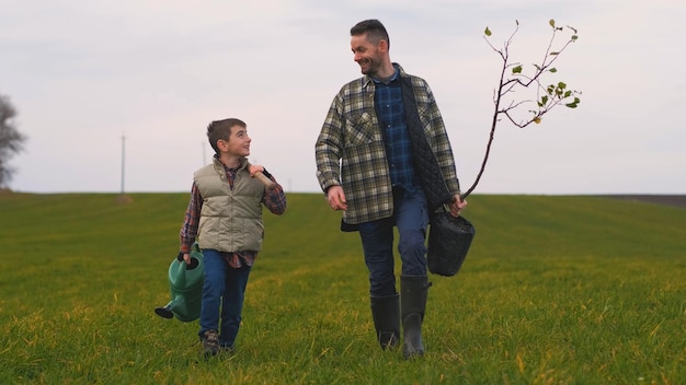 Le papa avec son petit fils va planter un arbre