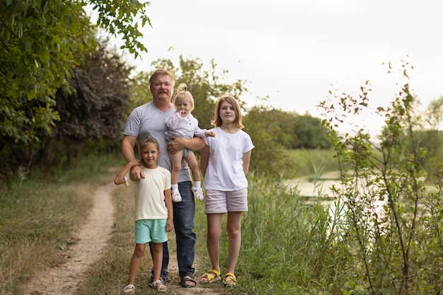 Papa avec trois enfants dans la nature