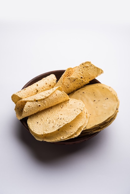 Papad ou papadum gujarati sous forme séchée crue avec cône rôti, rouleau et variation plate