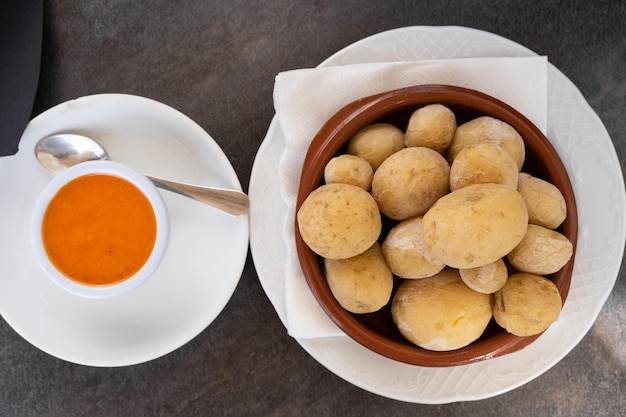 Papas arrugadas dans une assiette d'argile et sauce mojo épicée sur le côté du haut Pommes de terre ridées traditionnelles