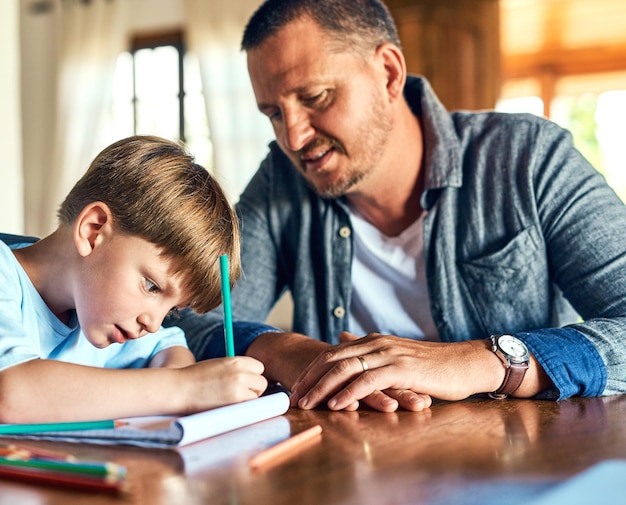 Des papas prêts à aider aux devoirs Photo d'un père aidant son fils à faire ses devoirs