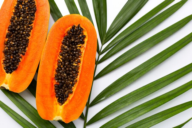 Photo papaye mûre sucrée sur des feuilles de palmier tropical.