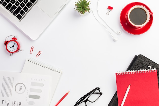 Papeterie de bureau avec réveil et tasse à café sur le bureau blanc