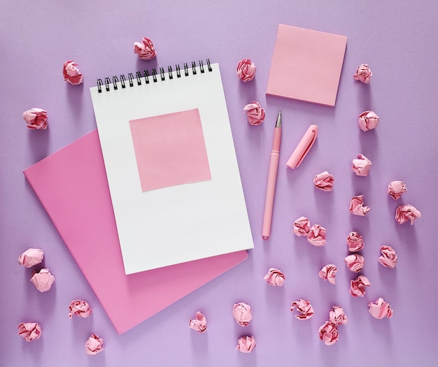 Papeterie pour l'école et le bureau en rose sur fond violet, vue de dessus