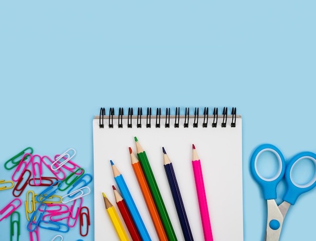 La papeterie scolaire colorée et le cahier blanc sur un fond bleu Flatlay Vue supérieure Retour à l'école