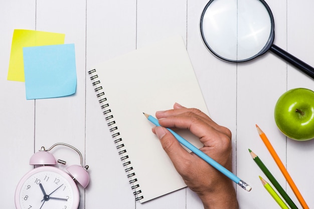 Papeterie scolaire ou fournitures de bureau sur fond de bois.