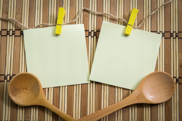 Papier blanc avec une cuillère en bois sur fond en bois, concept de cuisson.