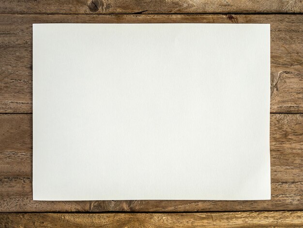 Photo un papier blanc sur la table en bois.