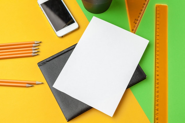 Papier blanc avec un téléphone intelligent sur le bureau.