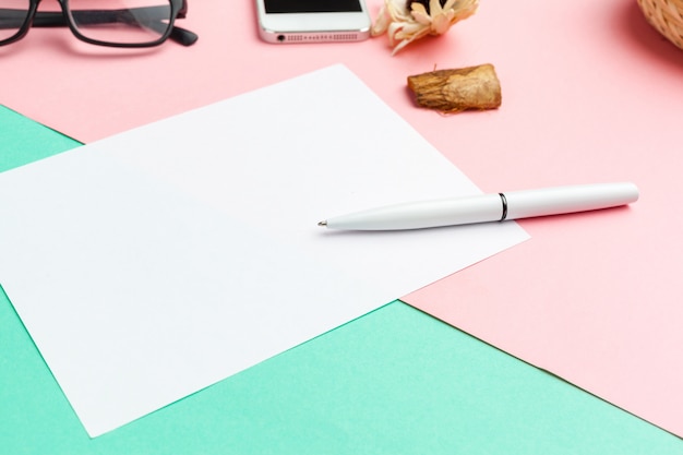 Papier blanc avec un téléphone intelligent sur le bureau