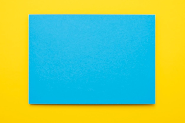 Un papier bleu sur fond jaune Copyspace