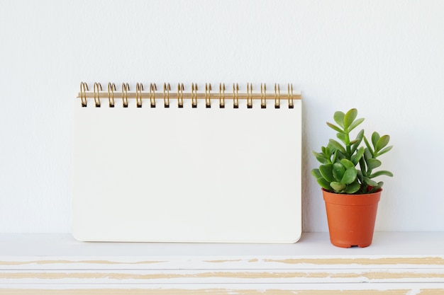 Papier de cahier vierge sur fond de tableau blanc