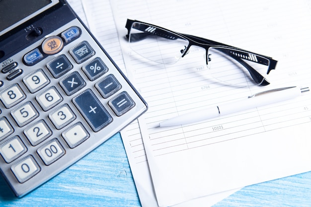 Papier, calculatrice et verres sur la table. concept de bureau