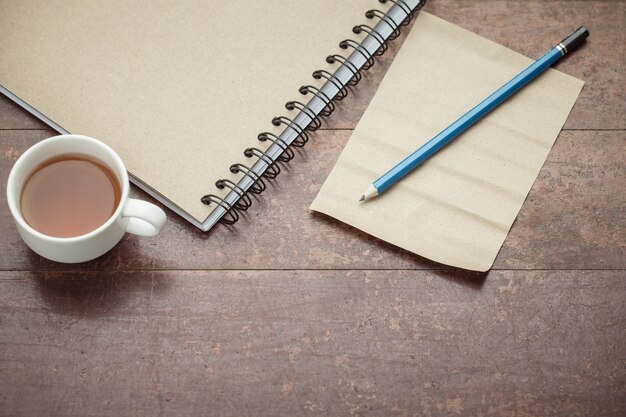 Papier et un crayon sur la vieille table en bois.