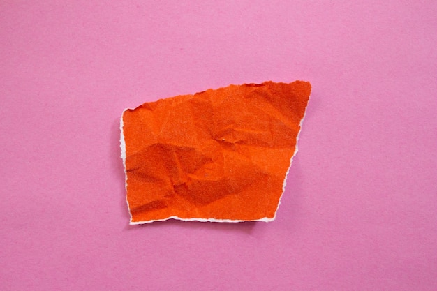 Papier déchiré blanc isolé sur fond rose. Vue de dessus du morceau de papier orange avec espace de copie.