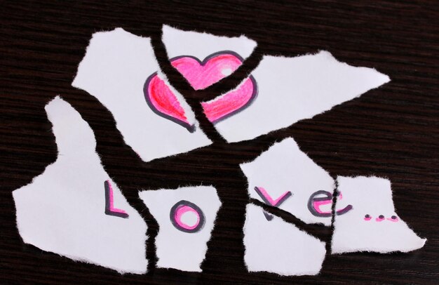 Papier déchiré avec des mots Love closeup sur table en bois