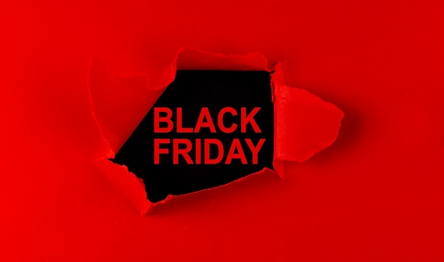 Photo papier déchiré rouge et inscription vendredi noir sur fond noir.
