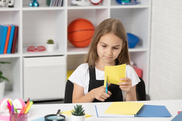 Papier découpé enfant concentré dans la salle de classe