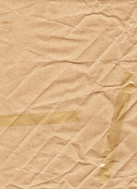 Papier d'emballage beige avec ruban adhésif à plis diagonaux et rides chaotiques