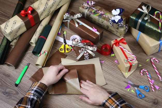 Papier d'emballage cadeau à la main pour le ruban et les arcs de Noël de vacances