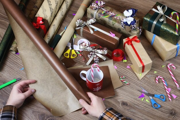 Photo papier d'emballage cadeau à la main pour le ruban et les arcs de noël de vacances