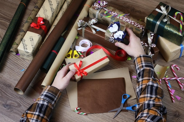 Papier d'emballage cadeau à la main pour le ruban et les arcs de Noël de vacances