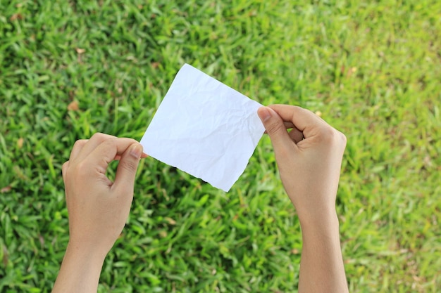 papier à la main sur fond d'herbe