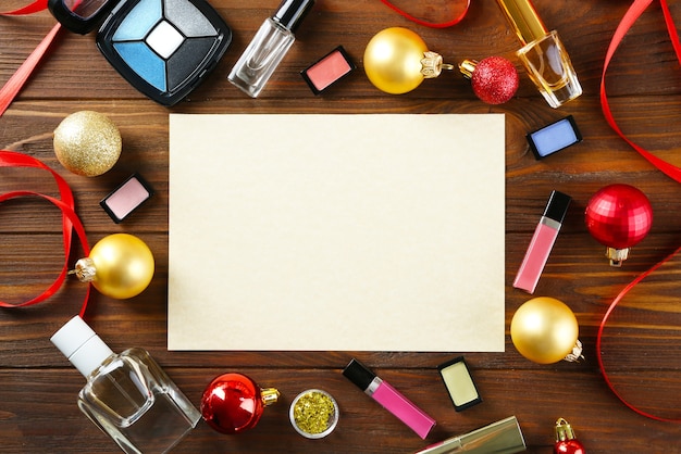 Papier avec maquillage coloré et décoration de Noël sur fond de bois