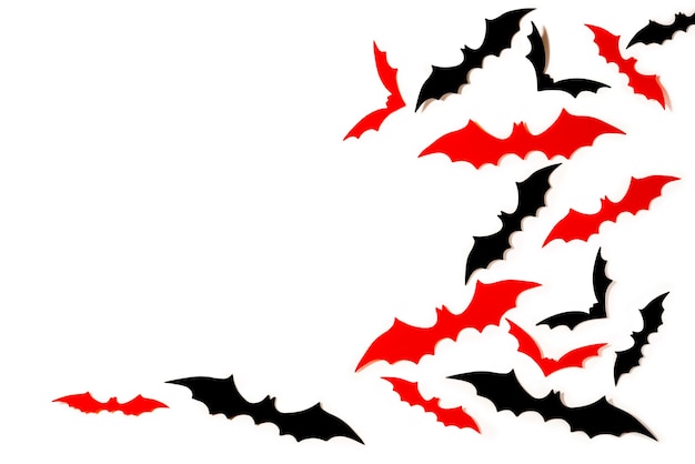 Papier noir et rouge coupé les chauves-souris survolant fond blanc. Fond de décoration Halloween avec espace de copie.