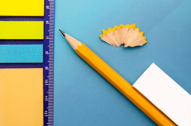Papier notes de couleurs différentes, crayon de bois jaune et caoutchouc.