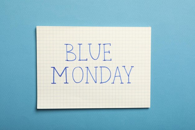 Papier avec texte Blue Monday sur fond bleu vue de dessus