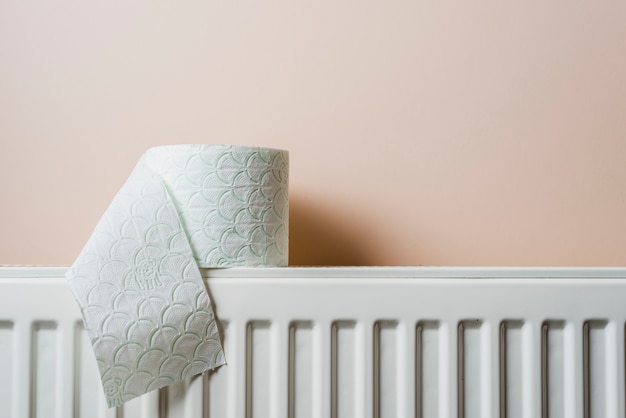 Photo papier toilette blanc sur radiateur contre mur