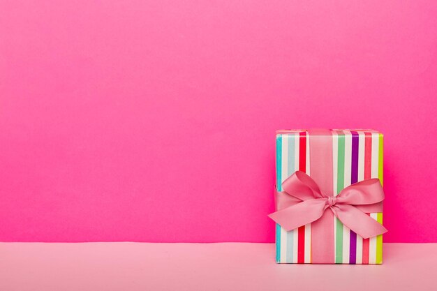 Papier de vacances présent attaché ruban rose arc vue de dessus avec espace de copie Fond de vacances plat poser Anniversaire ou cadeau de Noël Concept de boîte de cadeau de Noël avec espace de copie