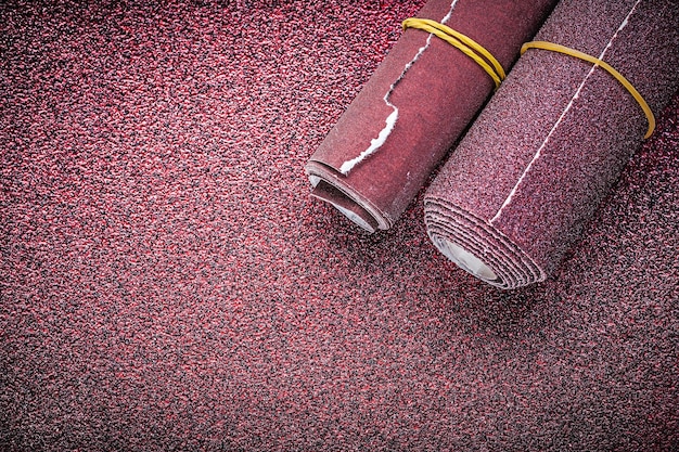 Papier de verre roulé sur feuille abrasive.