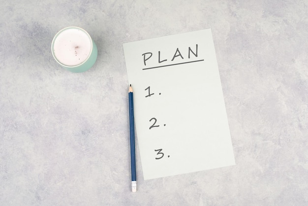 Un papier vide avec un stylo sur un fond texturé le plan du mot se trouve en haut de la page