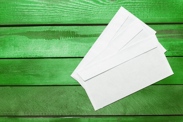 Papier vierge, enveloppe sur une table en bois verte