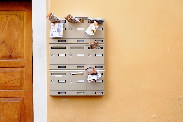 Des papiers dans la boîte aux lettres sur le mur.