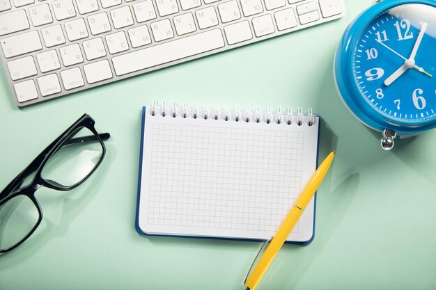 papiers avec ordinateur et horloge sur la table de travail