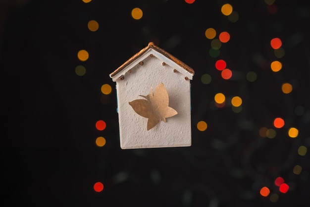 Papillon sur une maison modèle sur une lumière bokeh