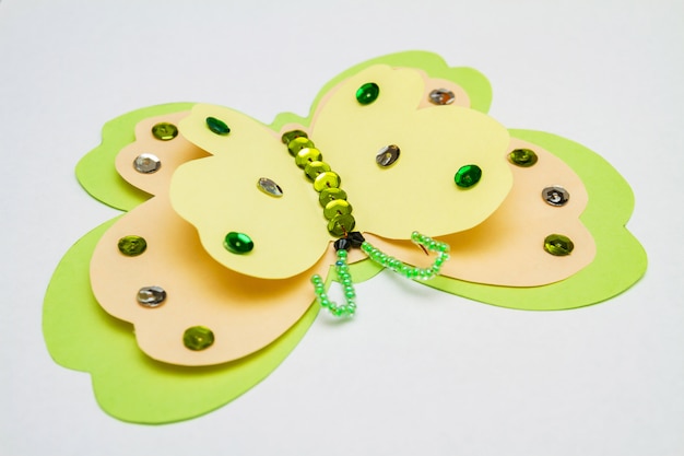 Papillon vert jaune en papier coloré, paillettes multicolores, paillettes et perles