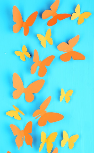 Papillons en papier sur fond de planche de bois bleu